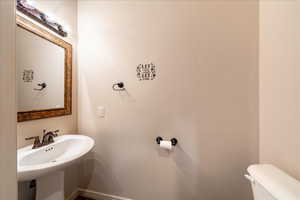 Half bathroom featuring toilet and baseboards