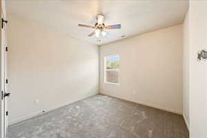 Empty room with carpet, a textured ceiling, and ceiling fan
