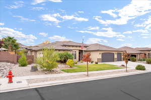 View of front facade with stucco siding, concrete driveway, a garage, a front yard, and a tile roof