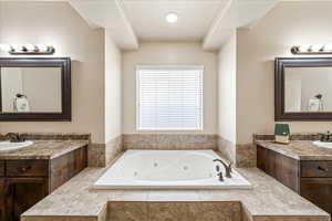 Bathroom with two vanities and a tub with jets