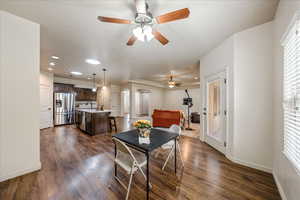 Dining space featuring arched walkways, dark wood finished floors, ceiling fan, and recessed lighting