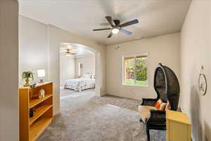 Bedroom with carpet floors, arched walkways, ceiling fan, and a textured ceiling