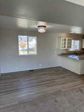 Unfurnished dining area featuring a textured ceiling, dark wood-style flooring, and a chandelier