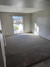Living room with carpet flooring and a textured ceiling
