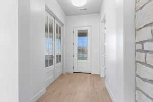 Doorway to outside with wood finished floors and baseboards