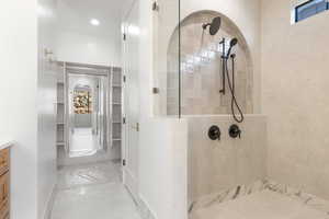 Bathroom with a walk in closet, a walk in shower, and vanity