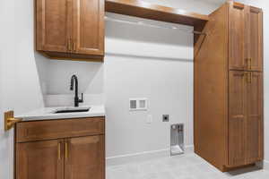 Washroom featuring cabinet space, hookup for a washing machine, and hookup for an electric dryer