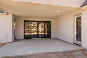 Entrance to property featuring stucco siding and a patio