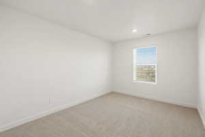 Carpeted empty room with baseboards and recessed lighting