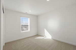 Carpeted empty room featuring baseboards and recessed lighting
