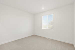Spare room featuring light carpet and recessed lighting