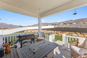 Deck featuring a fenced backyard, a mountain view, grilling area, and outdoor lounge area