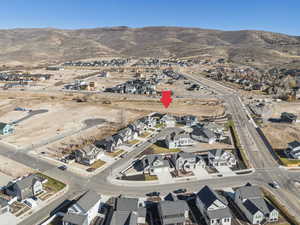 Aerial view of property and surrounding area featuring nearby suburban area and a mountain backdrop