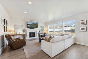 Living area featuring a glass covered fireplace, recessed lighting, and light wood-style floors