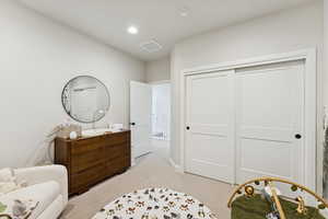 Bedroom featuring light colored carpet, a closet, and recessed lighting