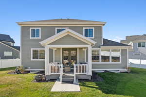 Rear view of house featuring a wooden deck, roof with shingles, an outdoor fire pit, and french doors