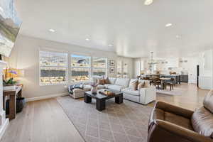 Living room with light wood-style floors, recessed lighting, and a chandelier