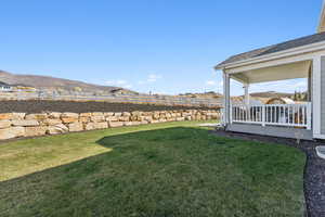 Fenced backyard featuring a deck with mountain view