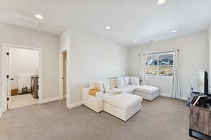 Living area featuring recessed lighting and light carpet