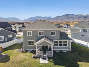 Rear view of property with a residential view, a fenced backyard, a patio area, and a shingled roof