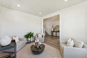 Living area with recessed lighting, wood finished floors, and stairs