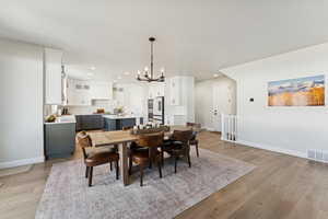Dining area with a chandelier, light wood-style flooring, and recessed lighting