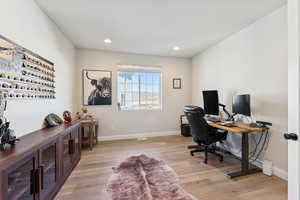Office space with light wood-type flooring and recessed lighting