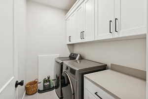 Washroom featuring cabinet space and washing machine and dryer