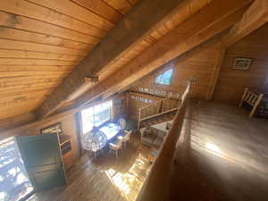 Bedroom with wooden ceiling, wood walls, and hardwood / wood-style floors