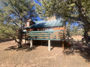 View of side of property with a metal roof and a wooden deck