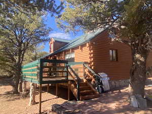 View of side of home featuring stairs, a metal roof, and log exterior