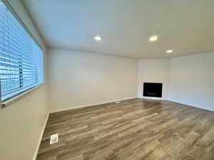 Unfurnished living room with a fireplace, light wood-type flooring, and recessed lighting
