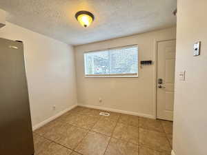 Spare room featuring light tile patterned floors and a textured ceiling
