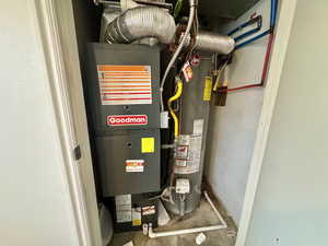 Utility room featuring heating unit and water heater