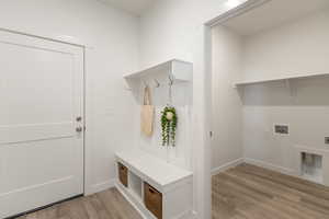 Mudroom with light wood-style flooring and baseboards
