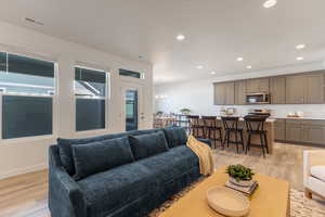 Living area featuring light wood-style floors, recessed lighting, and a chandelier