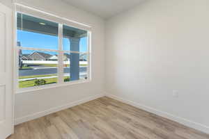 Spare room featuring light wood-type flooring and a residential view