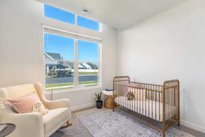Carpeted bedroom with a nursery area and baseboards