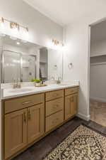 Bathroom with a spacious closet, a shower stall, and double vanity