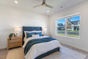 Carpeted bedroom with ceiling fan and recessed lighting
