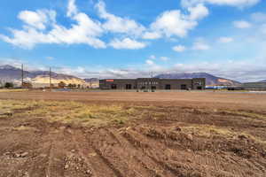 Rear view of house with a mountain view, a view of rural / pastoral area, and stucco siding