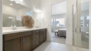 Ensuite bathroom with double vanity, a stall shower, light tile patterned flooring, and light carpet