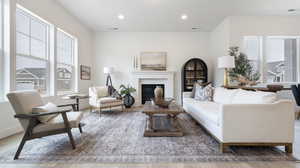 Living area with a glass covered fireplace, light wood-style flooring, and recessed lighting
