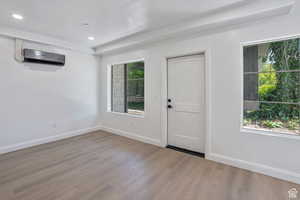 Entrance foyer with wood finished floors, recessed lighting, and a wall mounted air conditioner