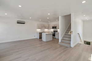 Kitchen with open floor plan, light countertops, a kitchen island, recessed lighting, and stainless steel appliances