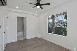 Unfurnished bedroom with recessed lighting, wood finished floors, ceiling fan, and ensuite bathroom