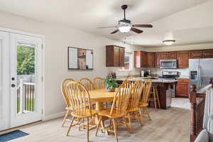 Dining room with light wood-type flooring and a ceiling fan