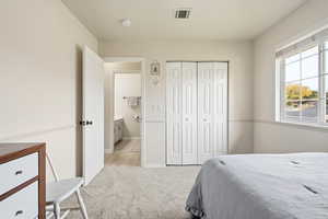 Bedroom with light carpet and a closet