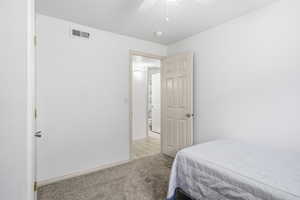 Carpeted bedroom featuring ceiling fan and baseboards