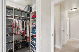 Walk in closet featuring light wood-style floors